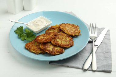 Beyaz ahşap masada servis edilen leziz patatesli krepler, yakın plan.