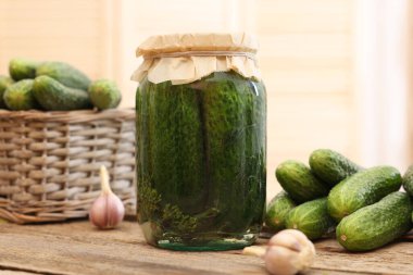 Kavanozda salatalık turşusu ve ahşap masada soğan, yakın plan.