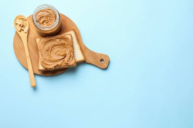 Fıstık ezmeli lezzetli sandviç ve açık mavi masada taze fındık. Metin için boşluk