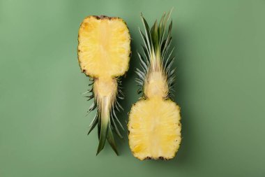 Yeşil arka planda taze ananas yarımları.