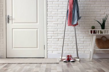 Koridorda giysili ve spor ayakkabılı metal askılar.