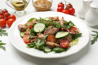 Lezzetli taze ton balığı salatası beyaz masada, yakın plan.