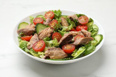 Lezzetli taze ton balığı salatası beyaz masada, yakın plan.