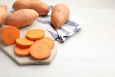 Taze patates ve mutfak havlusu beyaz masada, yakın plan. Metin için boşluk