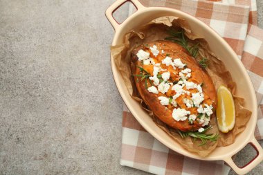 Lezzetli fırında patates, peynirli, limonlu ve otlu, gri desenli masa manzaralı. Metin için boşluk