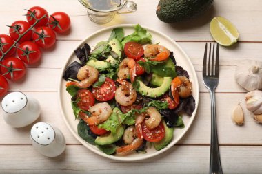 Lezzetli karides salatası ve malzemeler beyaz ahşap masada, düz yatıyordu.