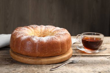 Taze pişmiş sünger kek ve ahşap masada çay.