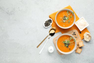 Açık gri desenli masada servis edilen lezzetli balkabağı çorbası.