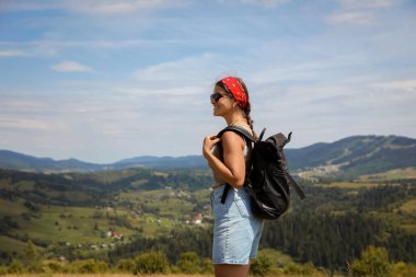 Sırt çantalı gülümseyen turist manzaranın tadını çıkarıyor. Metin için boşluk