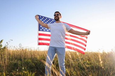 Amerika bayrağı taşıyan mutlu bir adam, alçak açılı.