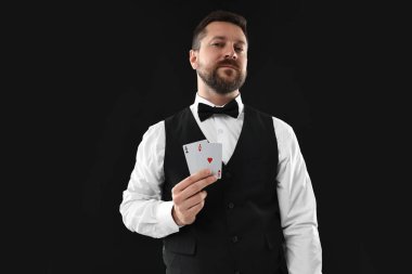 Siyah arkaplanda oyun kartları olan profesyonel krupiye