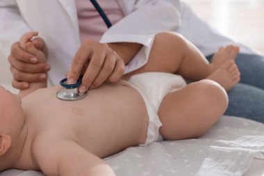 Pediyatrist, klinikte steteskoplu küçük bir çocuğu muayene ediyor. Bebeğin sağlığını kontrol ediyorum.