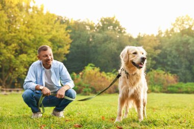 Gülümseyen adam ve tatlı Golden Retriever köpeği bahar günü