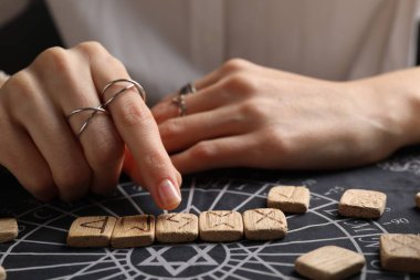 Kehanet minderinde tahta rünleri olan kadın, yakın plan.