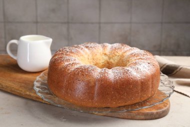 Taze pişmiş kek ve süt açık gri masada, yakın plan.