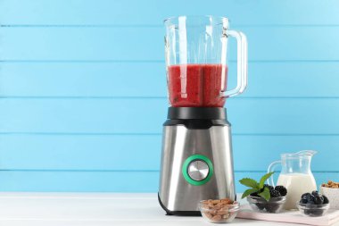 Malzeme karışımı ile karıştırıcı ve diğer taze ürünler beyaz ahşap masa üzerinde, metin için yer