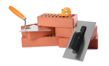 Kırmızı tuğlalar, mala, mezura ve beyaz üzerine izole edilmiş macun bıçağı. Yapı malzemeleri ve inşaat araçları