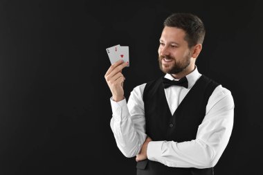 Siyah arkaplanda oyun kartları olan profesyonel krupiye, metin için boşluk