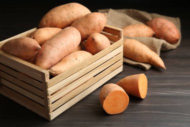 Tahta masadaki sandıkta taze çiğ patates, yakın plan.