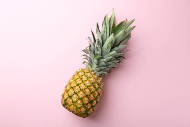 Pembe arka planda taze, olgun bir ananas.