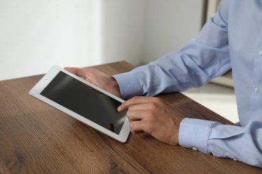İşadamı ahşap masada tablet kullanıyor, yakın plan. Modern teknoloji