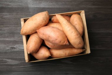 Tahta masadaki sandıkta taze çiğ patatesler.