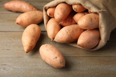 Tahta masada taze çiğ patatesli çuval, yakın plan.