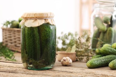 Kavanozda salatalık turşusu ve ahşap masada malzemeler, yakın plan.