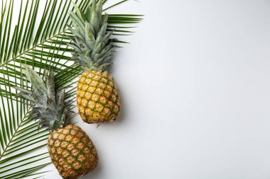 Beyaz arka planda taze ananas ve palmiye yaprakları, düz. Metin için boşluk