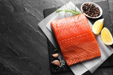 Siyah masada taze somon, limon ve baharat var. Metin için boşluk
