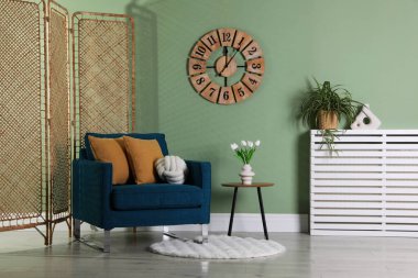 Katlanan ekran, rahat koltuk, yastıklar ve yan masa.