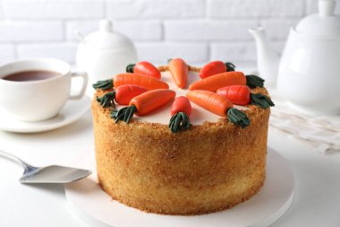 Lezzetli havuçlu kek, sunucu ve çay beyaz masada, yakın plan.