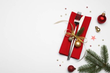 Noel sofrası. Çatal bıçak takımı, peçete ve beyaz arka planda şenlikli dekor. Metin için boşluk