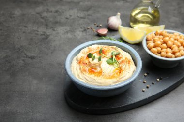 Koyu gri masada servis edilen kırmızı biberli lezzetli humus.