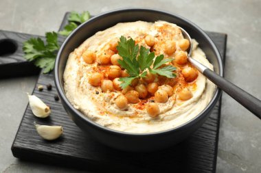 Maydanozlu enfes humus, kırmızı biber ve nohut gri masada, yakın plan.