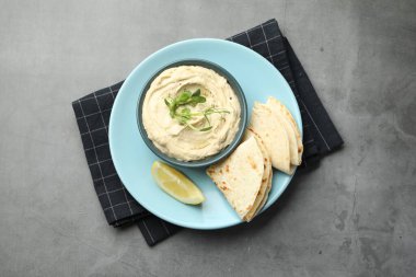 Kasede leziz humus, gri masada pide ve limon, üst manzara.
