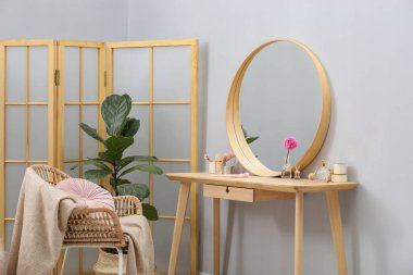 Ayna, tuvalet masası, ev bitkisi, katlanan ekran ve içeride sandalye. İç tasarım