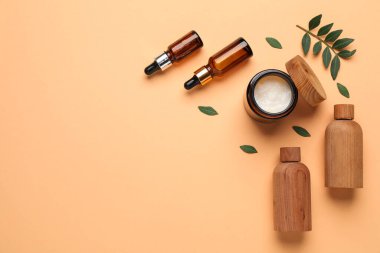 Soluk turuncu arka planda farklı kozmetik ürünleri. Metin için boşluk