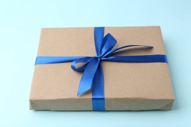 Renkli arka planda mavi fiyonklu hediye kutusu, yakın plan