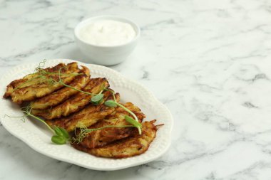 Beyaz mermer masada servis edilen lezzetli patates krepleri. Metin için boşluk