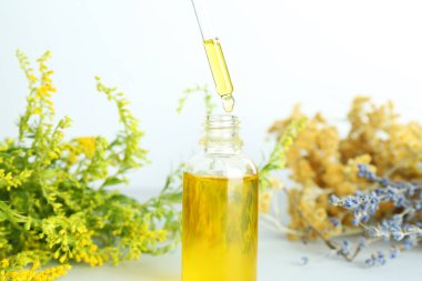 Tütünü pipetten şişeye, otları da beyaz arka plana damlatıyor. Yakın plan.