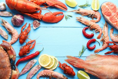 Açık mavi ahşap masa üzerinde farklı deniz ürünleri çerçevesi, düz yatıyordu. Metin için boşluk