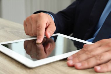 İşadamı ahşap masada tablet kullanıyor, yakın plan. Modern teknoloji
