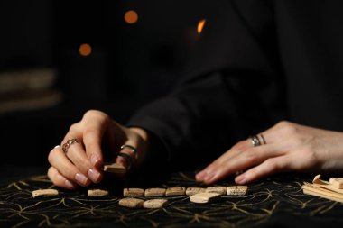 Kehanet minderinde tahta rünleri olan kadın, yakın plan.