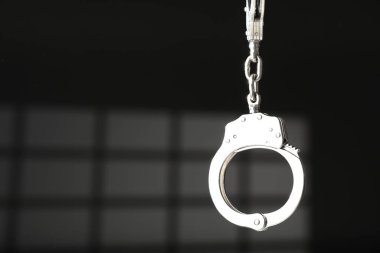 Koyu arka planda metal zincir kelepçeler, yakın plan. Metin için boşluk