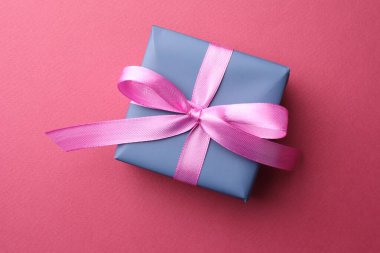 Pembe arka planda fiyonklu güzel hediye kutusu, üst manzara