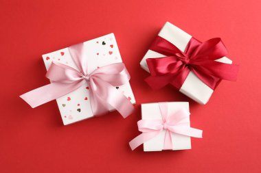 Kırmızı arka planda fiyonklu hediye kutuları, düz yatıyordu