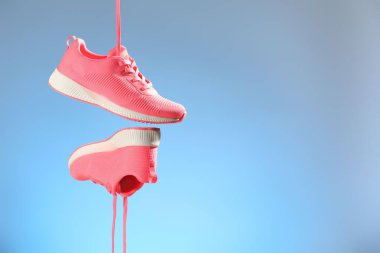 Açık mavi arkaplana karşı havada şık spor ayakkabılar, metin için boşluk