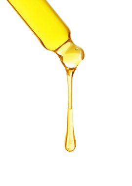 Temel yağ beyaz arka planda pipetten damlıyor