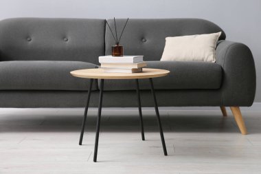 Rahat bir kanepe ve gri duvarın yanındaki masa.